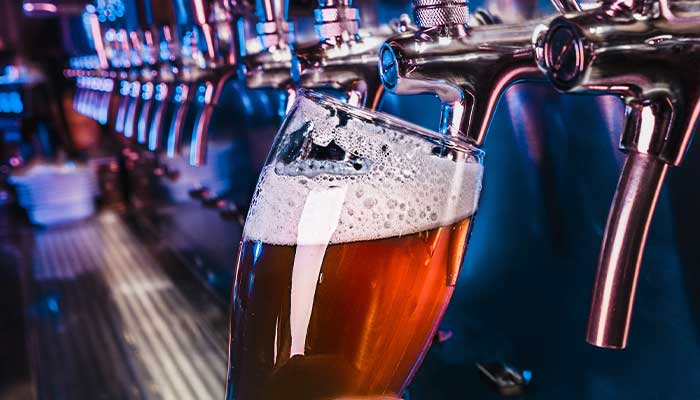 Ice cold craft import and domestic draft beer is poured and tapped into pilsner glass at The Lodge of Spring Grove restaurant, bar and grill in Illinois